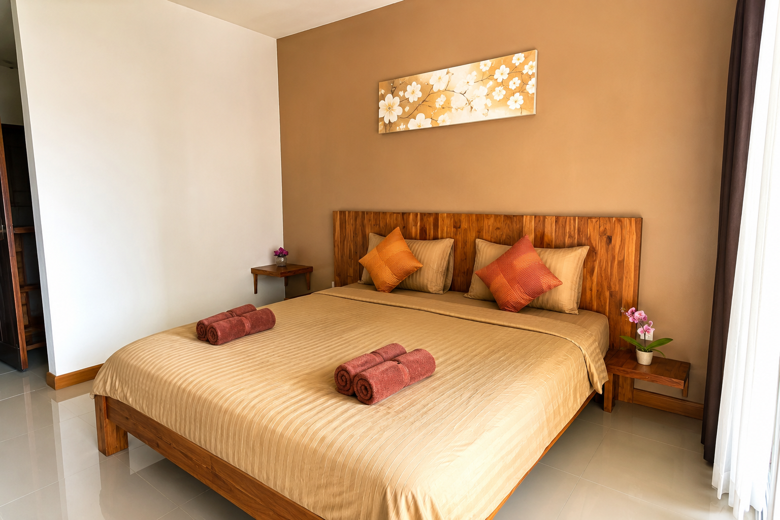 Gemütliches Schlafzimmer mit Doppelbett, Holz-Headboard, Kissen, dekorativen Handtuchrollen und Blumen auf Nachttischen.